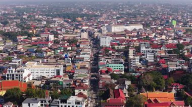 Şehir merkezindeki stadyumun çatıları, kentsel gelişimi ve inşaat vinçlerinin yer aldığı yüksek açılı Vientiane, Laos panoraması..
