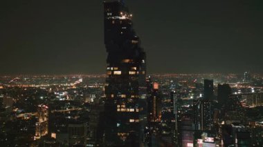 Eşsiz pikselleştirilmiş Kral Güç Mahanakhon gökdeleni Tayland 'da geceleri karanlık gökyüzüne karşı Bangkok şehir manzarasını aydınlatıyor..