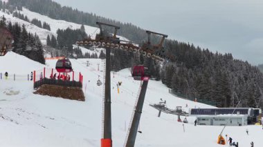 Kayak teleferiği gondollarının kış tatillerinde Alplerdeki karlı dağ yamaçlarına eğlence ve spor aktiviteleri için taşıması..