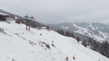 Avusturya 'nın Saalbach kentindeki soğuk bir kış gününde insanlar Alp dağlarında teleferik ve teleferikle kayak yapıyor..