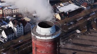 Almanya 'nın Bielefeld kentinin üzerine buhar yayan endüstriyel baca hava perspektifinden enerji üretimi ve kirliliği gösteriyor.