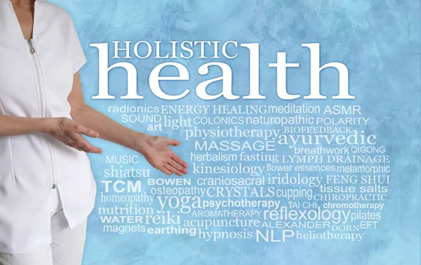 There are so many different Holistic health therapies to choose from - female therapist with hands gesturing towards a HOLISTIC HEALTH word tag cloud on a pale blue wispy background