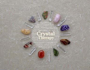 Kristal Terapi Şebekesi Taşları Kelime Çemberi - dokuz farklı yuvarlanan taş ve yok edilmiş kuvars değneği bir CRYSTYAL THERAPY kelime bulutu etrafında bir daire çiziyor kırsal lifli kabarık renkli bir kağıt üzerinde