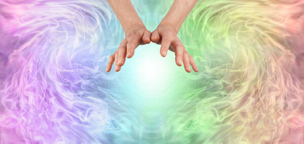 Отправка дистанционного исцеления через эфир к вам - женские руки зависают над белым светом в окружении радужного цвета энергетического поля с копировальным пространством вокруг