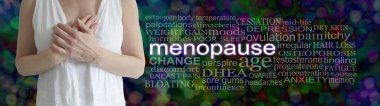 Dişi menopozla ilgili kelimeler. Koyu renkli bir bokeh arka planda MENOPAUSE kelime bulutunun yanında elleri göğsünde olan olgun bir kadın.
