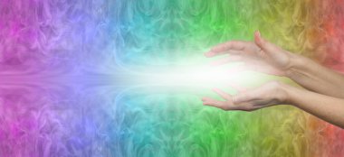 Güzel çok renkli çakra iyileştirici enerji mesajı pankartı - mesajlar için fotokopi alanı olan gökkuşağı renkli bir arka plan arasında beyaz ışık ile sarılmış kadın elleri 