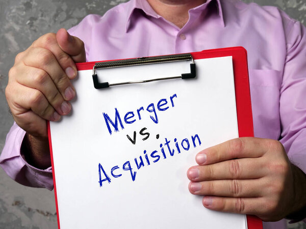  Financial concept meaning Merger vs. Acquisition with phrase on the piece of paper