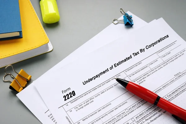 stock image  Financial concept meaning Form 2220 Underpayment of Estimated Tax By Corporations with inscription on the piece of paper