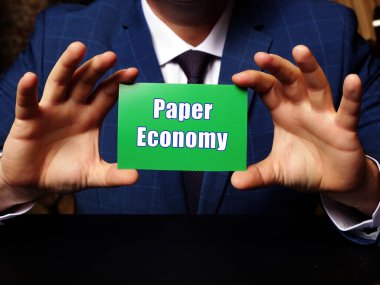Elinde boş bir kart tutan genç bir adam. Yazılı metinle Kağıt Ekonomi hakkında kavramsal fotoğraf