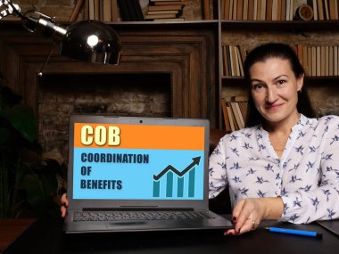 Ekran arka planında BENEFITS simgesinin COORDINATION 'una sahip dizüstü bilgisayar kullanan kadın, iş konseptinde başarı