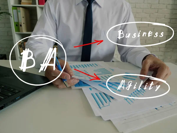 手書きのノートでBaビジネス敏捷性についての財務の概念ビジネスマンの手は紙ファイルのスタックで作業するためのペンを保持背景に関する情報ビジネスレポートの論文を検索 — ストック写真