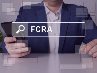 Adil Kredi Raporlama Yasası FCRA yazıtları ekranda. Modern Bankacının elleri siyah akıllı telefonu tutuyor. FCRA kredi bürolarının üniversiteyi nasıl yöneteceğini yönetir.