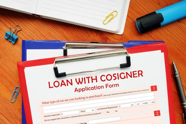 financial document in a hand with phrase LOAN WITH COSIGNER Application Form. Horizontal shot. Close-up