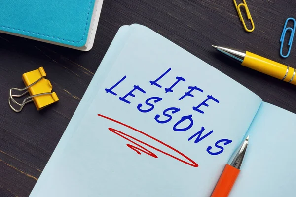 Financial concept meaning LIFE LESSONS with phrase on the sheet. A lesson which conveys something instructive or valuable about life or principles for living one\'s life