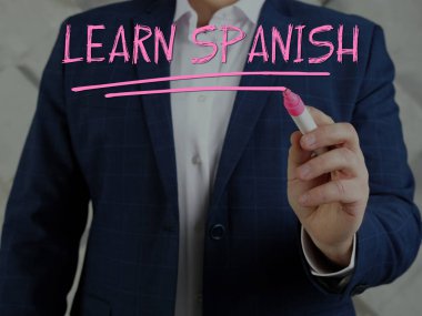 Banker işaretleyici kalemle saydam bir sanal arayüz üzerine Learn SPANISH yazıyor
