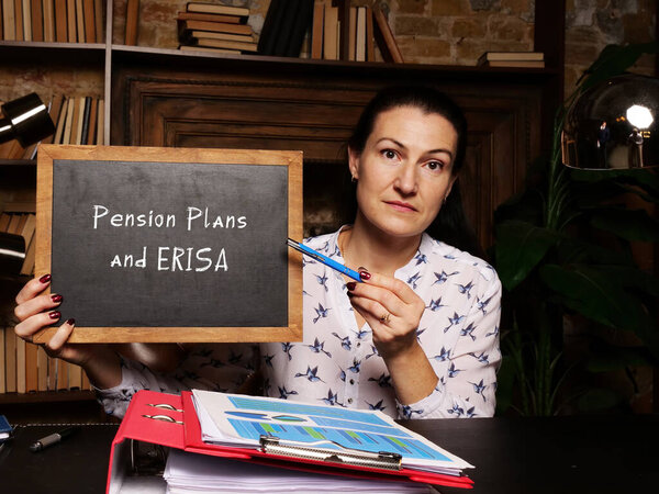 A handsome businessWoman showing a chalkboard with sign Pension Plans and ERISA . Close-up shot. Soft focus