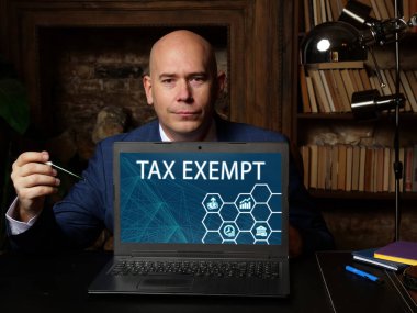 Business concept about TAX EXEMPT with inscription on the computer. Business concept about to be free from, or not subject to, taxation by regulators or government entitie clipart