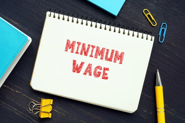 MINIMUM WAGE sign on the piece of paper. A minimum wage is the lowest remuneration that employers can legally pay their
