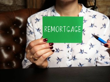  Financial concept about REMORTGAGE with inscription on the piece of paper. The process of paying off one mortgage with the proceeds from a new mortgage using the same property as securit clipart