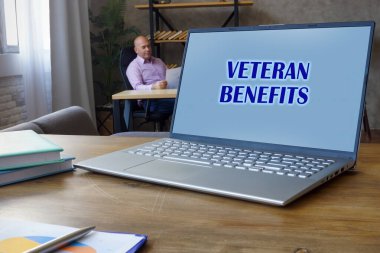 Finansal konsept VETERAN BENEFITS anlamına gelir kompakt dizüstü bilgisayarda ifade ile başarılı bir iş adamı arkaplanda belgeler ile