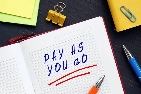 PAY AS YOU GO phrase on the sheet. Pay-as-you-go is a system in which a person or organization pays for the costs of something when they occur rather than before or afterward