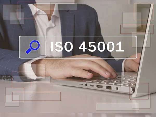  ISO 45001 ifadesi ekranda. Pazarlama uzmanı ofiste internet teknolojileri kullanıyor. Arama ve ISO 45001 kavramını kabul et .