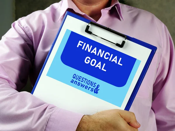 FINANCIAL GOAL text in search bar. Broker looking at cellphone.