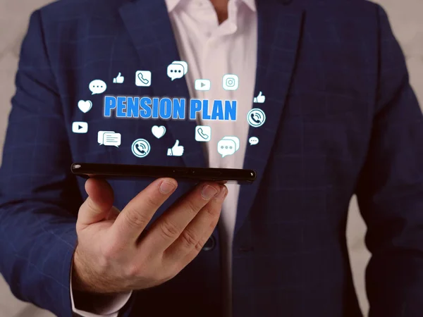 PENSION PLAN text in search line. Businessman looking at smartphone. An arrangement made with an employer to pay money to an employee after retirement