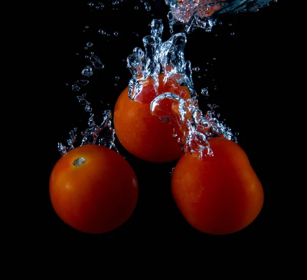 Tomat Jatuh Dalam Air Terisolasi Latar Belakang Hitam — Stok Foto
