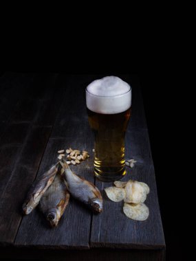 Bira ve balık, ahşap masada bira için aperatifler.