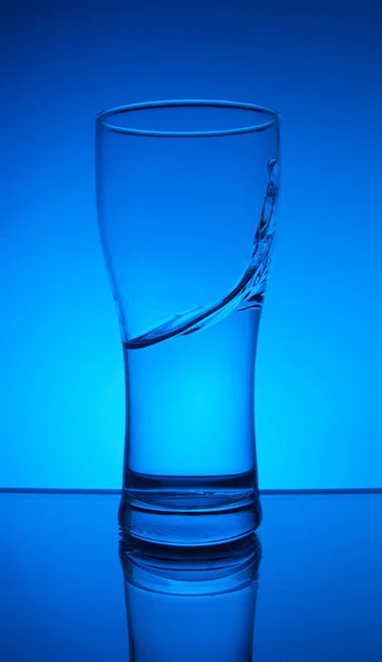 青い背景にガラスと水のスプラッシュ — ストック写真