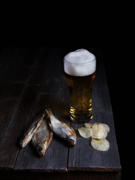 Bira ve balık, ahşap masada bira için aperatifler.