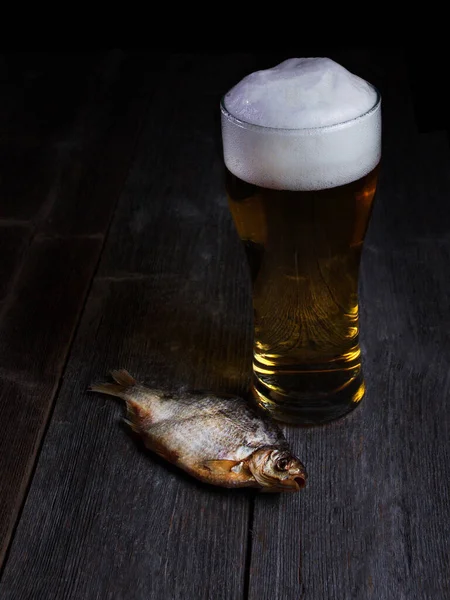 Bira ve balık, ahşap masada bira için aperatifler.