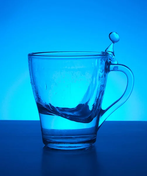 Kaca Dan Percikan Air Pada Latar Belakang Biru — Stok Foto