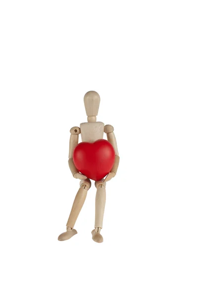 Wooden model doctor holding a heart symbol — Stok fotoğraf