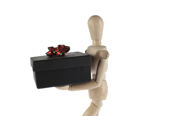 Wooden male model carries gift box — Stockfoto