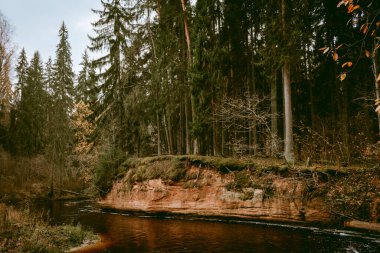 Letonya 'da bulutlu bir sonbahar gününde Amata Nehri kıyısında Stuku Rock