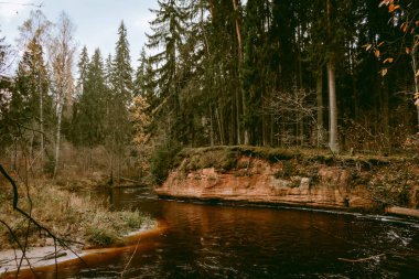 Letonya 'da bulutlu bir sonbahar gününde Amata Nehri kıyısında Stuku Rock