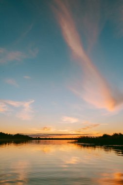 Sıcak yaz akşamı Letonya 'daki Lielupe nehrinin üzerinde gün batımı