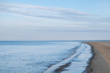 Güneşli bir günde sakin Baltık Denizi, mavi gökyüzü ve Letonya, Carnikava yakınlarında bulutlar