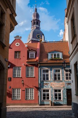 Riga Eski Kasabası 'nın dar sokaklarında güzel bir mimari ve arkasında Riga Kubbesi Katedrali var.