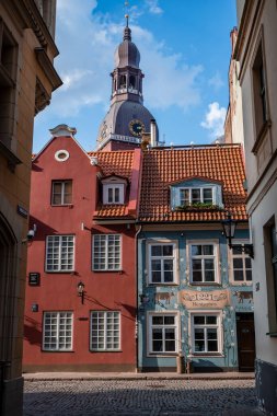 Riga Eski Kasabası 'nın dar sokaklarında güzel bir mimari ve arkasında Riga Kubbesi Katedrali var.
