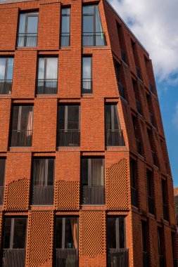 Mavi gökyüzü olan kırmızı tuğla ev ve arka planda beyaz bulutlar Riga Eski Kasabası, Letonya