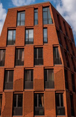 Mavi gökyüzü olan kırmızı tuğla ev ve arka planda beyaz bulutlar Riga Eski Kasabası, Letonya