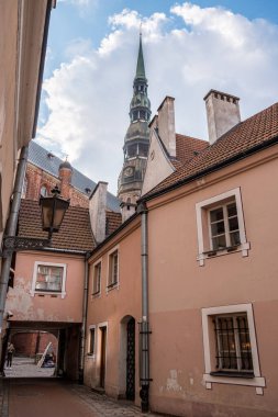 Arka planda Aziz Peter Kilisesi olan Riga Eski Kasabasının dar sokakları