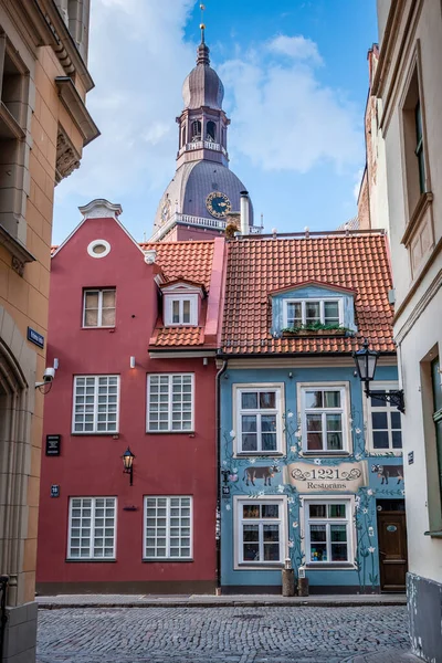 Riga Eski Kasabası 'nın dar sokaklarında güzel bir mimari ve arkasında Riga Kubbesi Katedrali var.