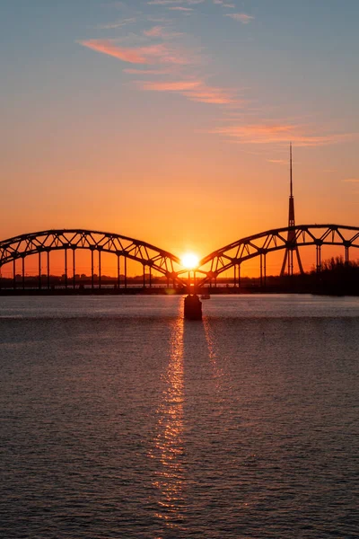 Avrupa Birliği 'nin en yüksek kulesine sahip Daugava nehri ve demiryolu köprüsü üzerinde renkli gün doğumu - Riga, Letonya' daki Radyo ve TV kulesi