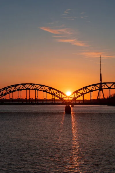 Avrupa Birliği 'nin en yüksek kulesine sahip Daugava nehri ve demiryolu köprüsü üzerinde renkli gün doğumu - Riga, Letonya' daki Radyo ve TV kulesi