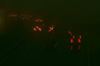 Gece otobandaki trafik ışıkları bulanıktı. Arka planda sis yükseliyor. Bokeh, arkaplan, karamsar ve klasik filtre