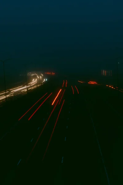 夜间公路上的交通灯模糊不清 雾气从后面升起 Bokeh Background Moody Vintage Filter — 图库照片